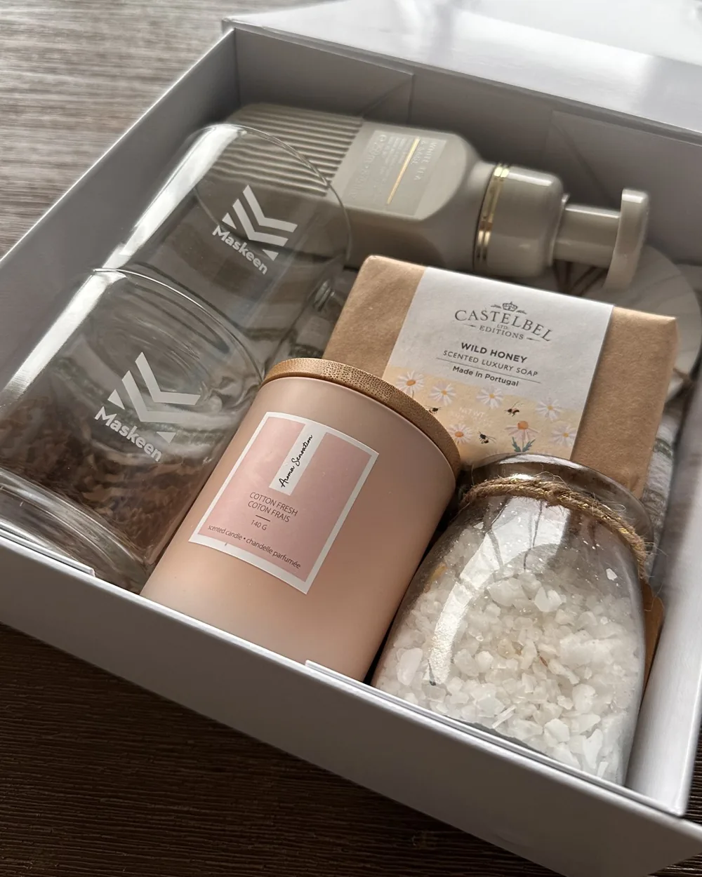 Close-up of a corporate gift box with a branded glass, honey soap, candle and bath salts